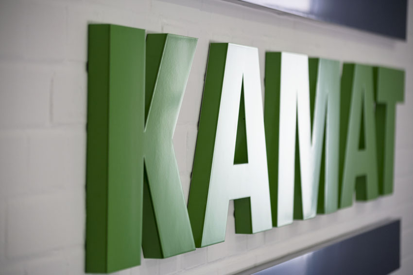 closeup of the KAMAT logo as plate in the company's entrance hanging on the wall