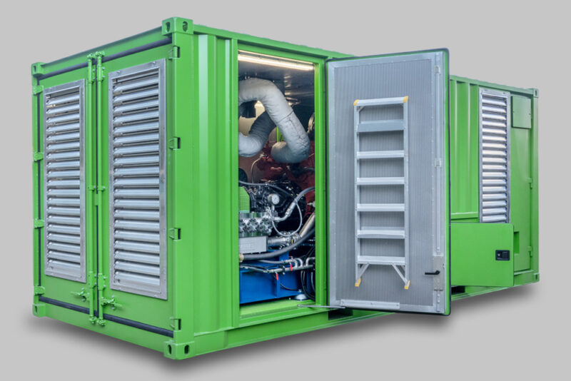 KAMAT green Container with main door open showing a glimps of the KAMAT high-pressure unit
