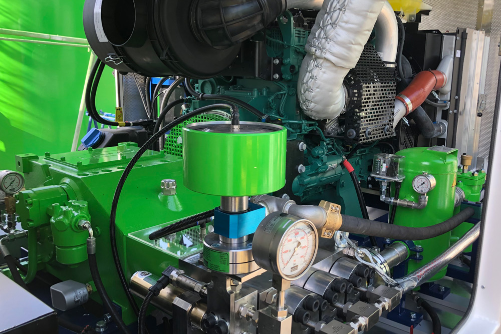 This picture shows the inside of the mobile high-pressure unit KamJet with the hp plunger pump K18000-3g with the unloader valve and the Volvo engine